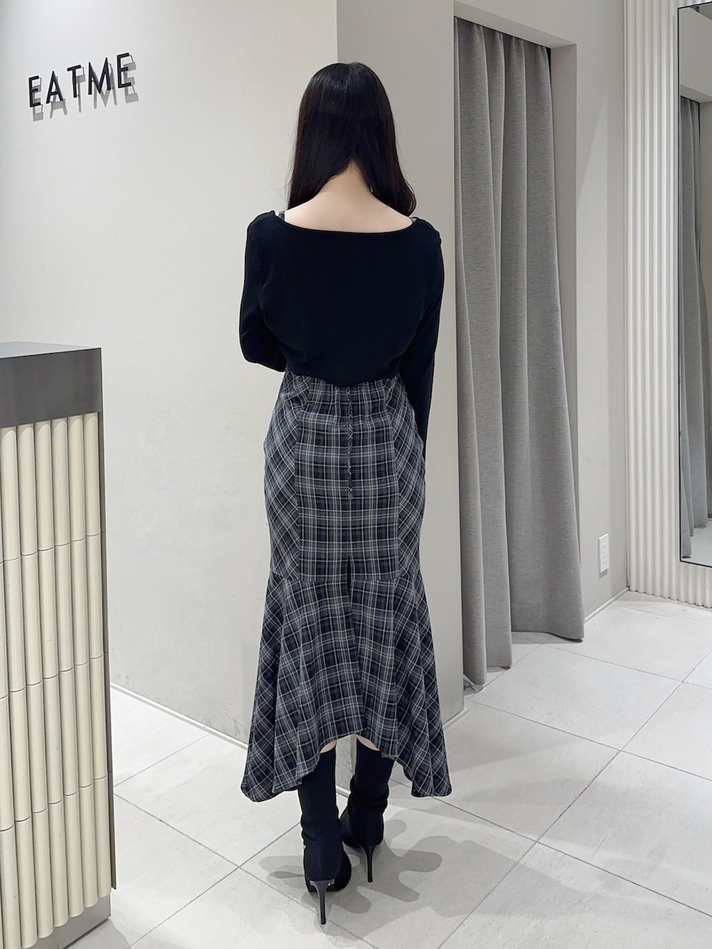 ブラック系のワンピース、ブラック系のブーツを着用したレディースの秋コーディネートの4枚目の写真