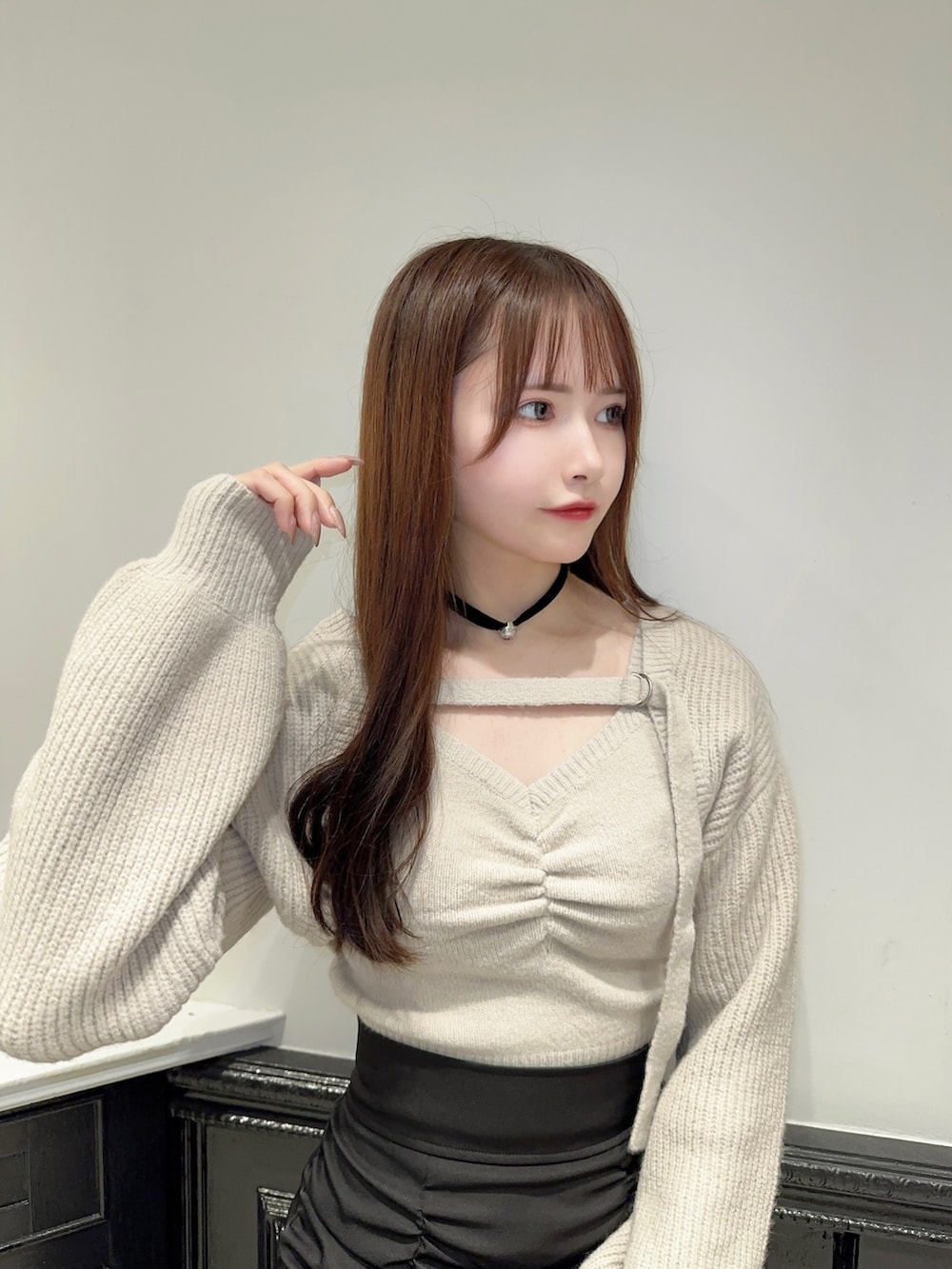 グレー系のニット/セーター、ブラック系のスカート、ブラック系のパンプスを着用したレディースの秋コーディネートの4枚目の写真