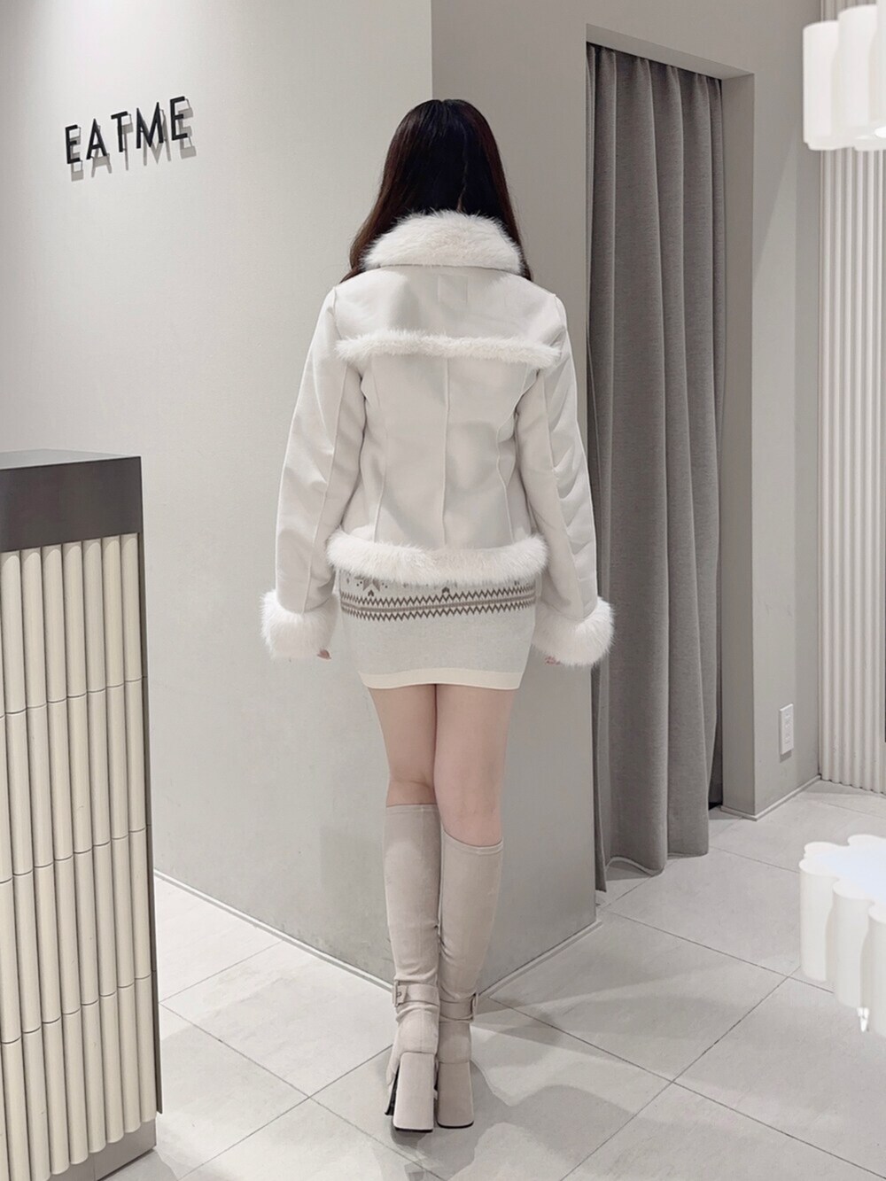 ブラウン系のショルダーバッグ、ホワイト系のブーツ、ホワイト系のスカートを着用したレディースの秋コーディネートの5枚目の写真