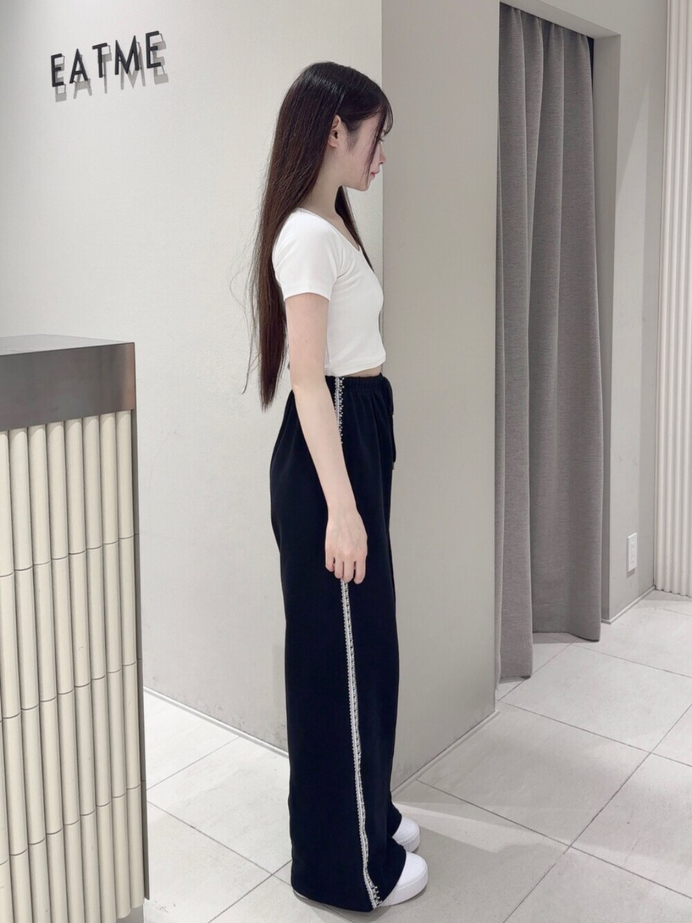 ホワイト系のスニーカー、ホワイト系のTシャツ/カットソー、ホワイト系のショルダーバッグを着用したレディースの夏コーディネートの3枚目の写真