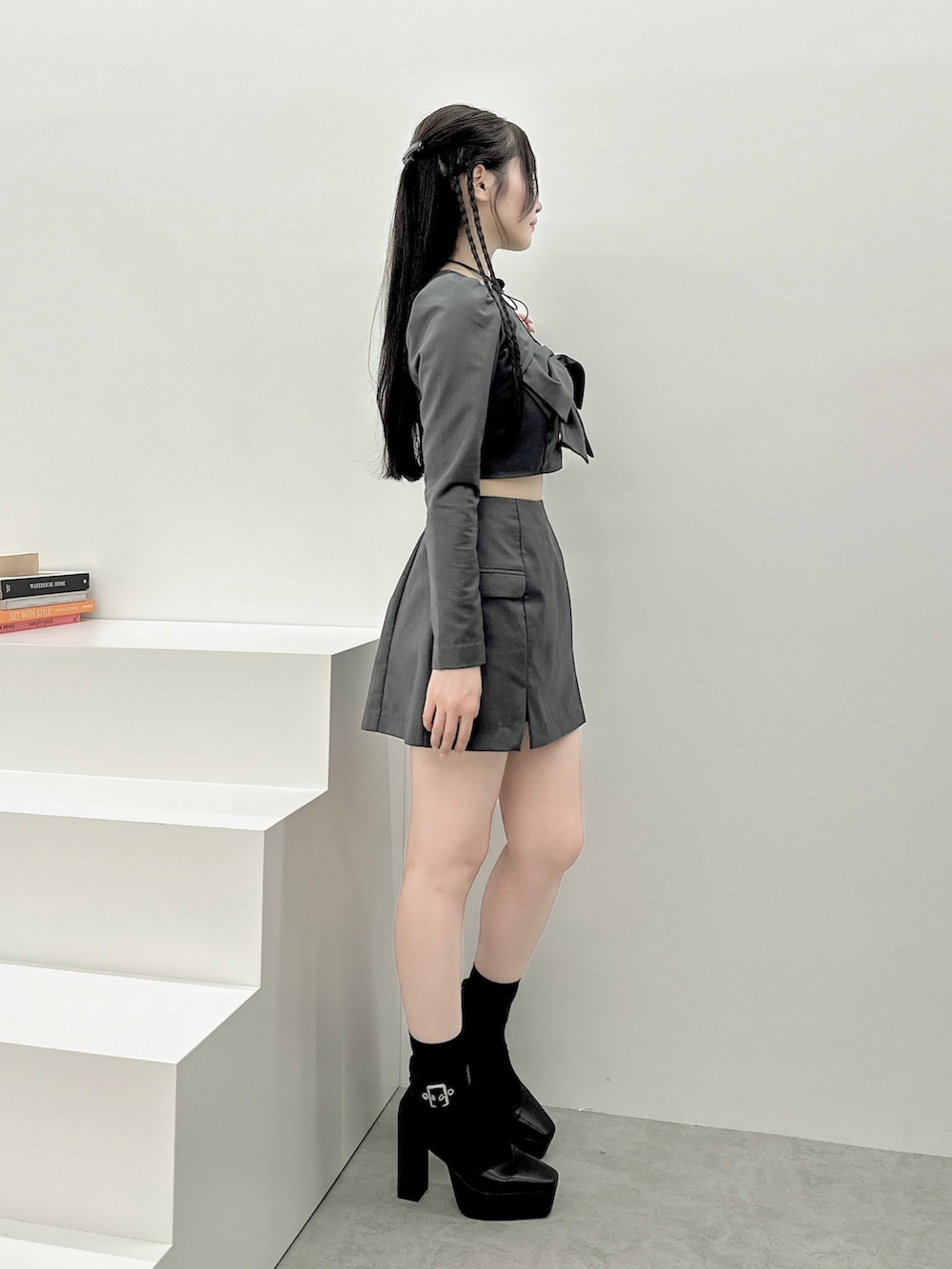 グレー系のワンピース、ブラック系のパンプス、ブラック系のバレッタ/ヘアクリップを着用したレディースの秋コーディネートの3枚目の写真