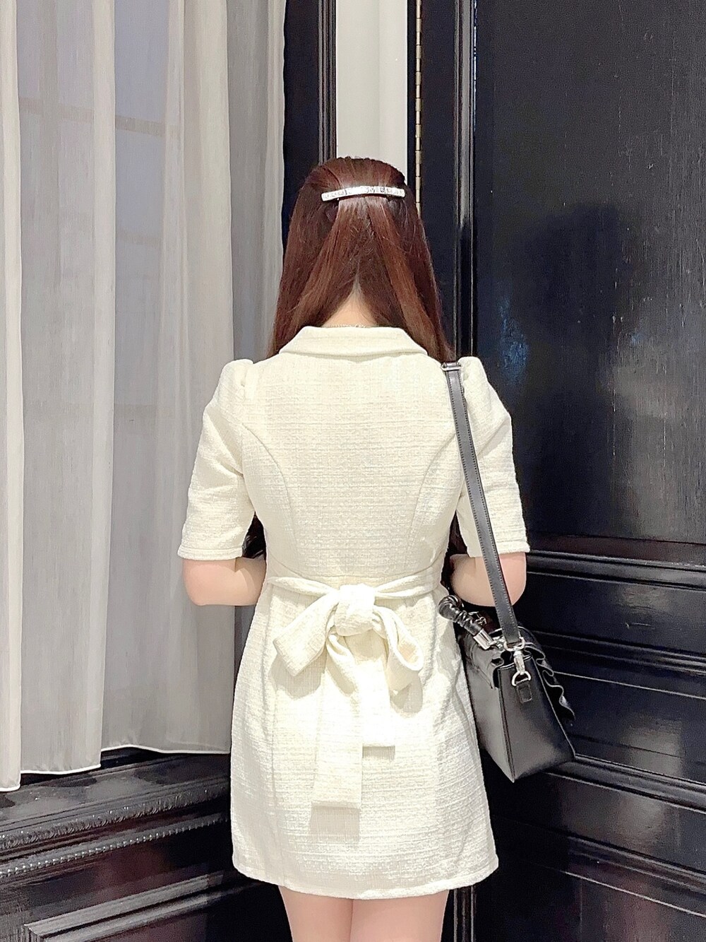 ホワイト系のワンピース、ブラック系のハンドバッグ、ブラック系のパンプスを着用したレディースの夏コーディネートの4枚目の写真