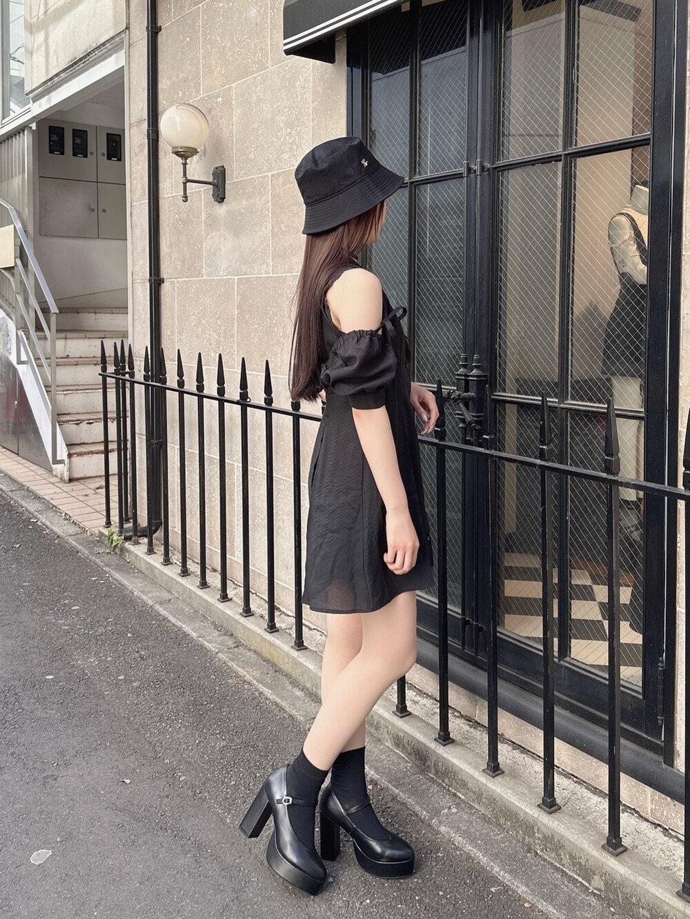 ブラック系のワンピース、ブラック系のパンプス、ブラック系のハットを着用したレディースの冬コーディネートの3枚目の写真