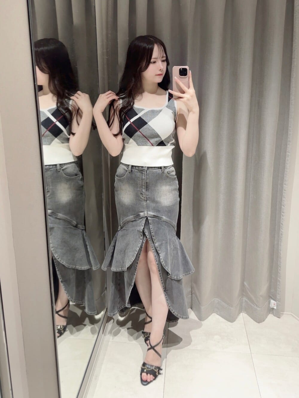 ブラック系のサンダル、ブラック系のデニムスカート、ホワイト系のニット/セーターを着用したレディースの夏コーディネートの2枚目の写真