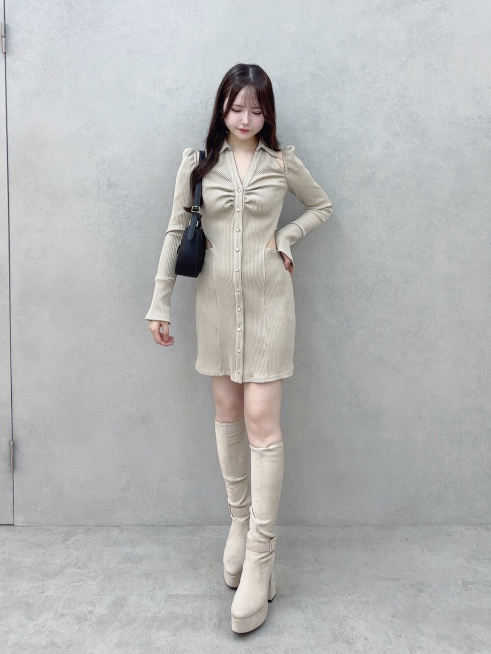 ブラック系のショルダーバッグ、ベージュ系のワンピース、ホワイト系のブーツを着用したレディースの秋コーディネートの2枚目の写真