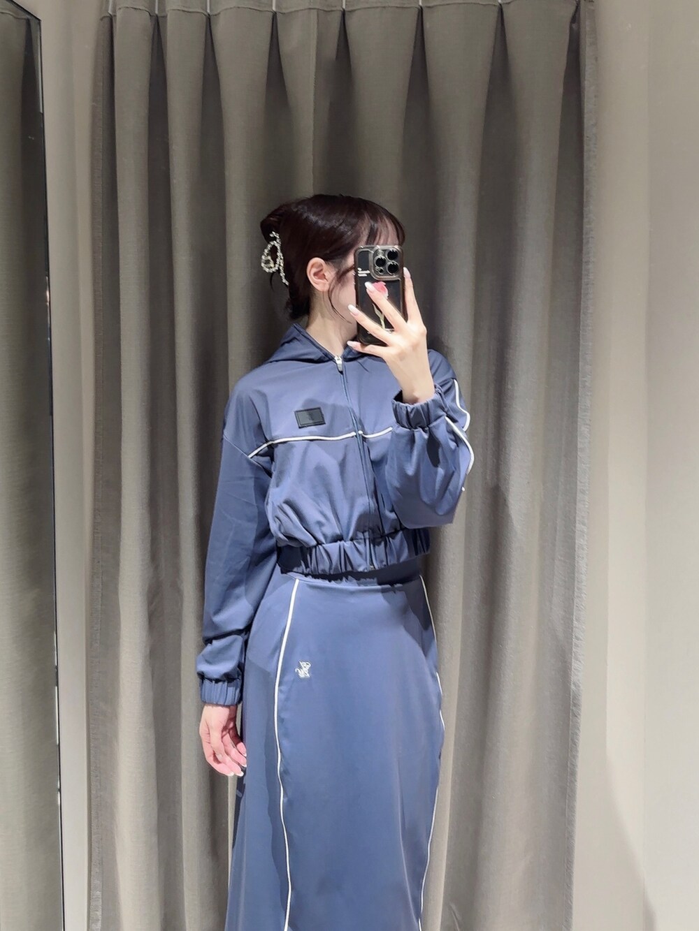 ブルー系のスカート、ブラック系のブーツ、ブルー系のナイロンジャケットを着用したレディースの秋コーディネートの5枚目の写真