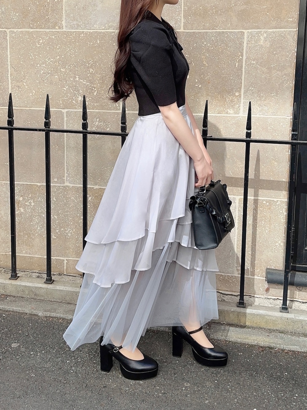 ブラック系のニット/セーター、グレー系のスカート、ブラック系のショルダーバッグを着用したレディースの春コーディネートの3枚目の写真