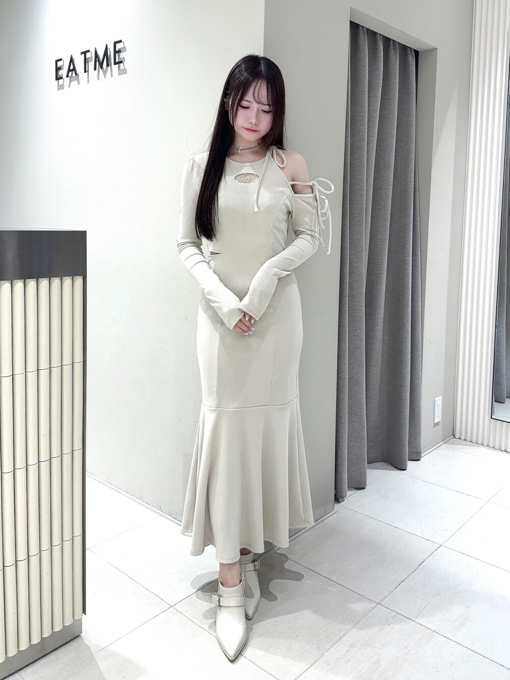 ホワイト系のワンピース、ホワイト系のブーツ、シルバー系のネックレスを着用したレディースの春コーディネートの2枚目の写真