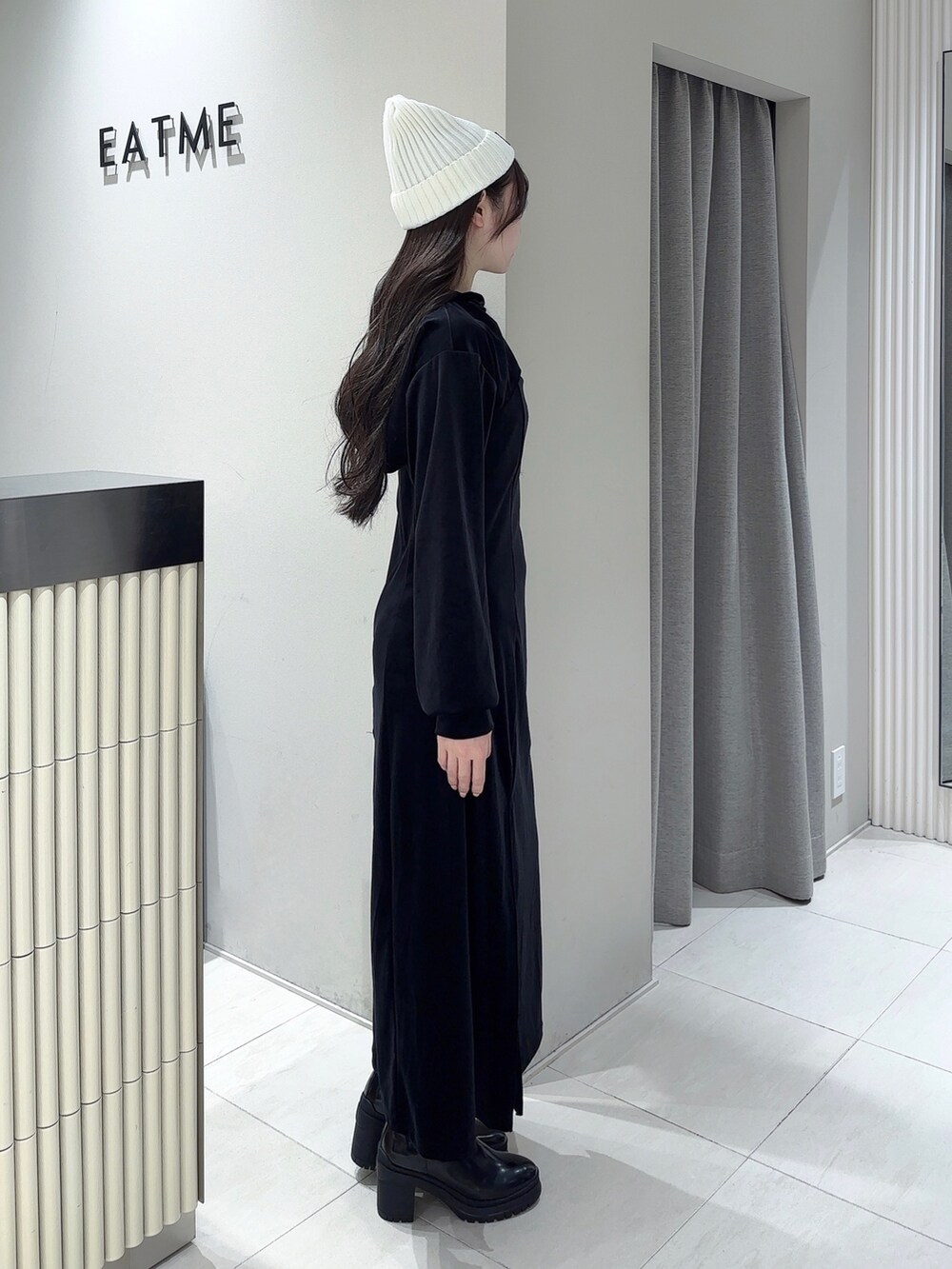 ブラック系のワンピース、その他のブーツ、ホワイト系のニットキャップ/ビーニーを着用したレディースの秋コーディネートの2枚目の写真