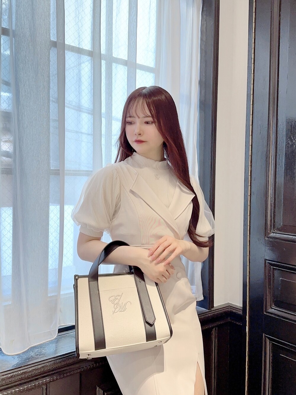 ホワイト系のニット/セーター、ホワイト系のスカート、ホワイト系のショルダーバッグを着用したレディースの春コーディネートの3枚目の写真