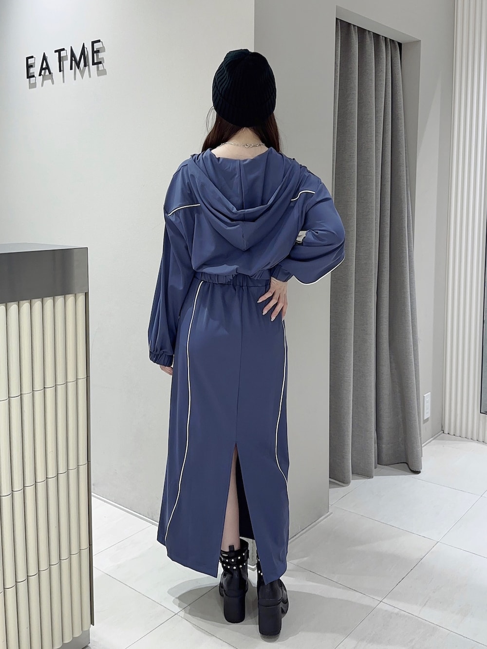 ブルー系のスカート、ブラック系のブーツ、ブルー系のナイロンジャケットを着用したレディースの秋コーディネートの3枚目の写真