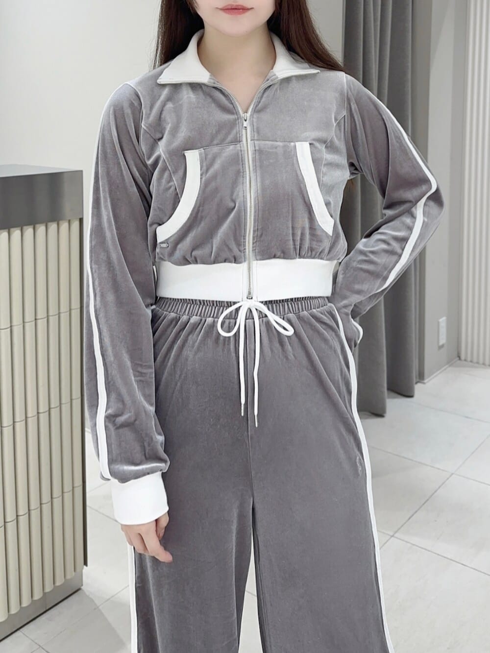 ホワイト系のスニーカー、グレー系のその他パンツ、グレー系のブルゾンを着用したレディースの秋コーディネートの5枚目の写真