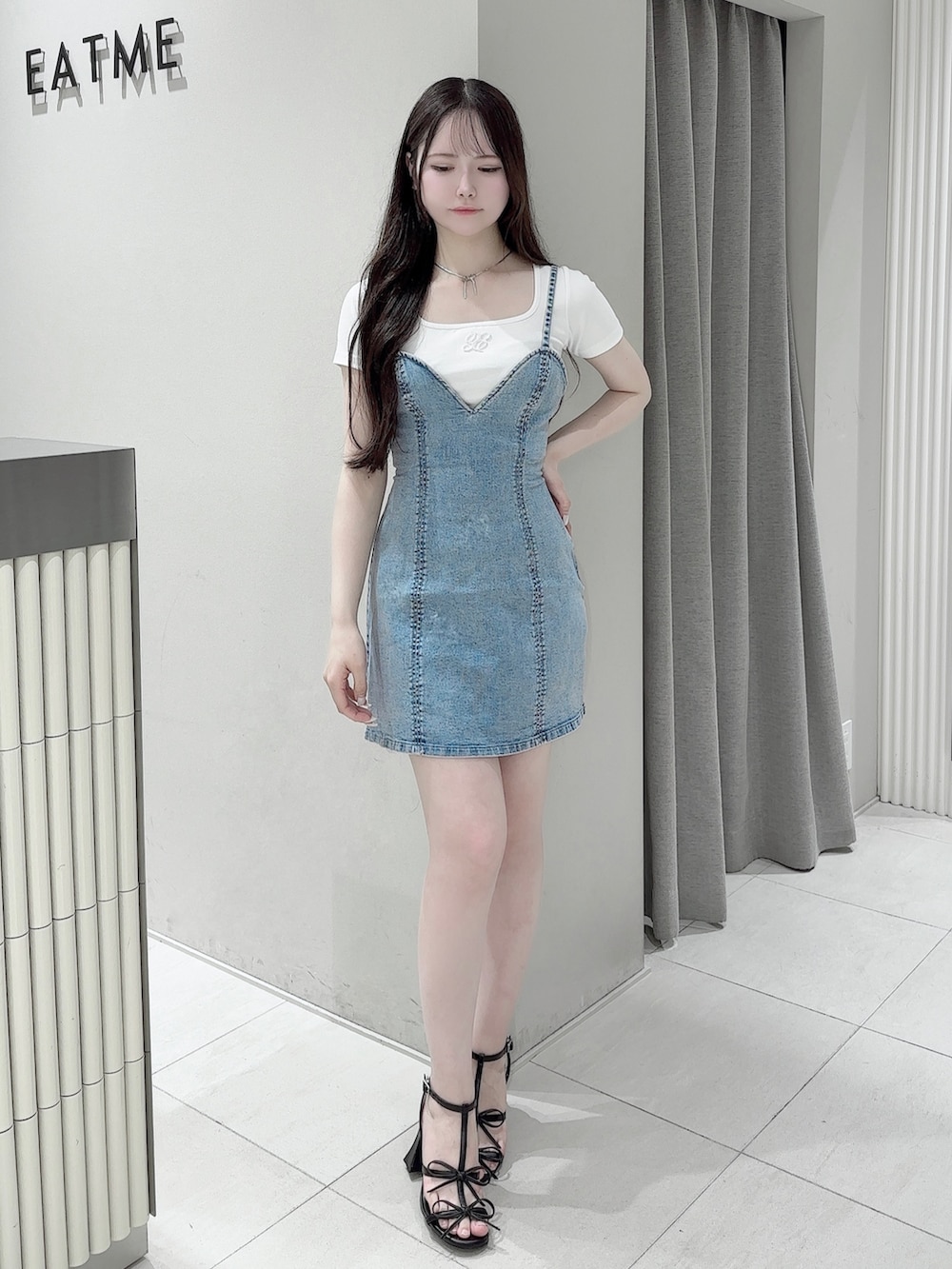 ブルー系のワンピース、ホワイト系のTシャツ/カットソー、ブラック系のサンダルを着用したレディースの夏コーディネートの2枚目の写真