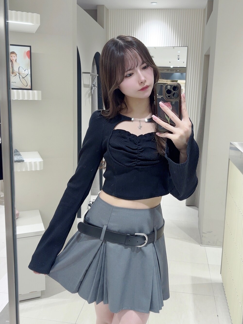 ブラック系のTシャツ/カットソー、グレー系のスカート、ブラック系のブーツを着用したレディースの冬コーディネートの5枚目の写真