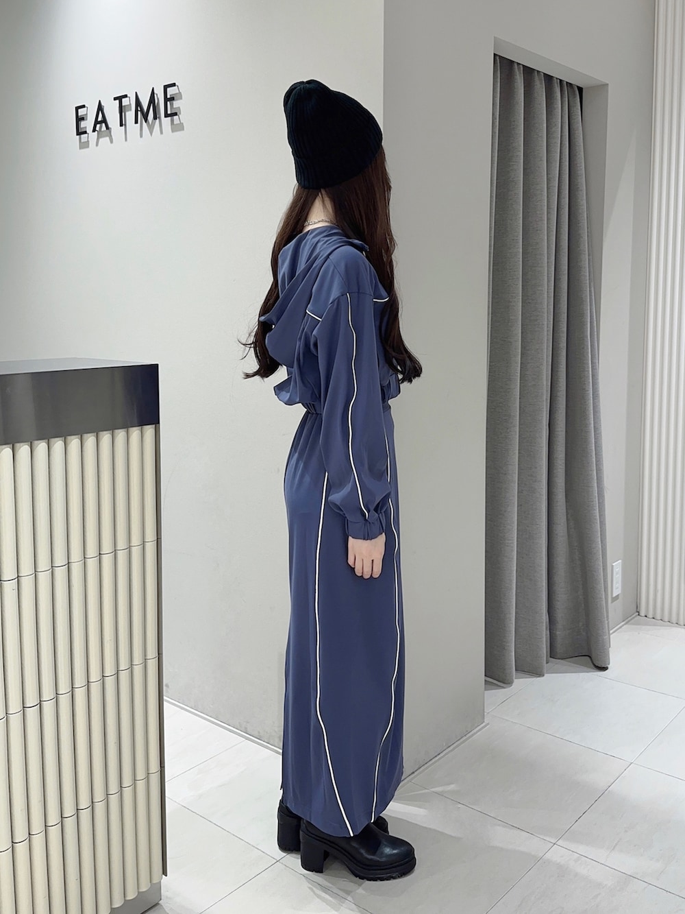 ブルー系のスカート、ブラック系のブーツ、ブルー系のナイロンジャケットを着用したレディースの秋コーディネートの2枚目の写真