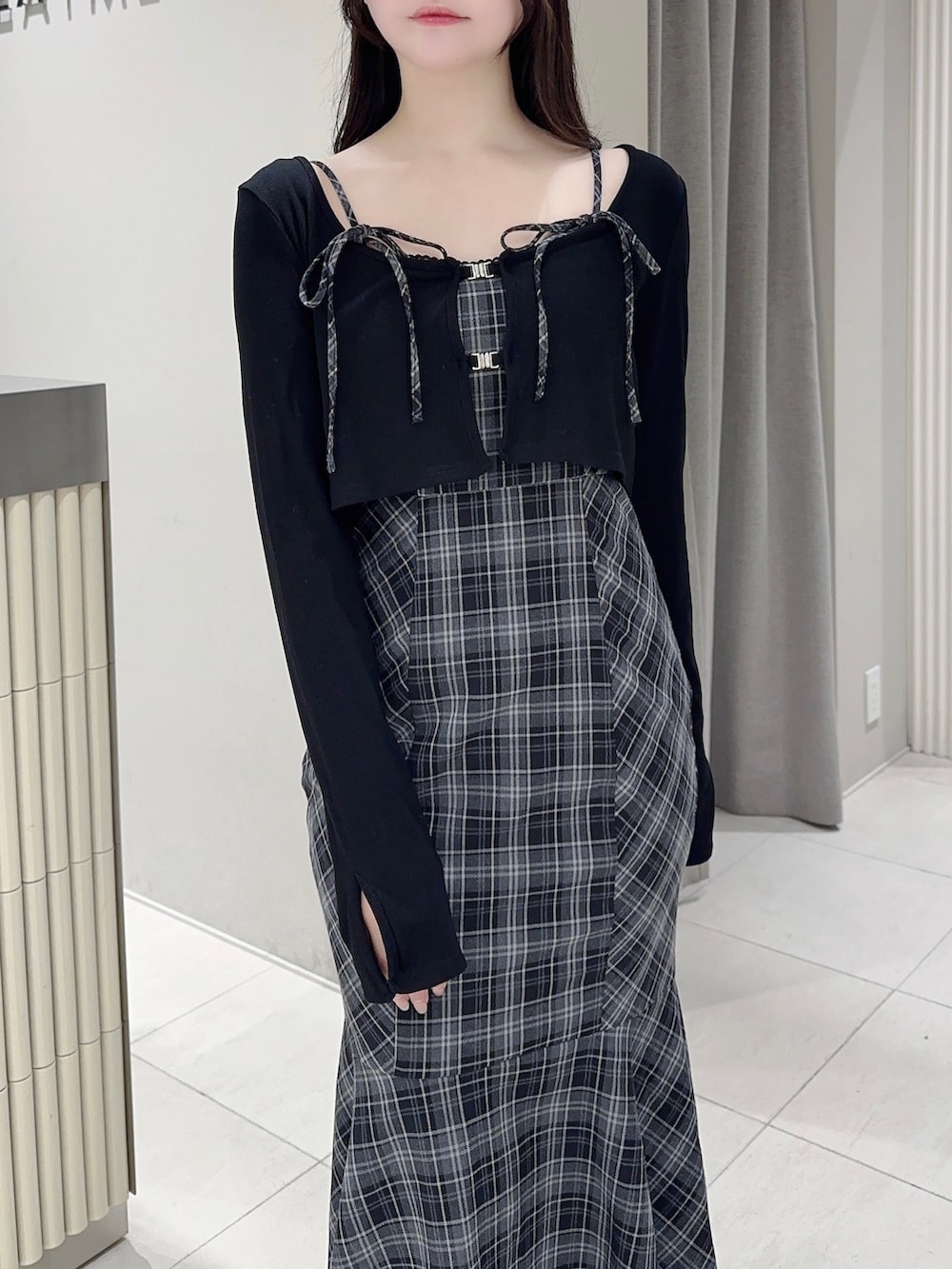 ブラック系のワンピース、ブラック系のブーツを着用したレディースの秋コーディネートの5枚目の写真