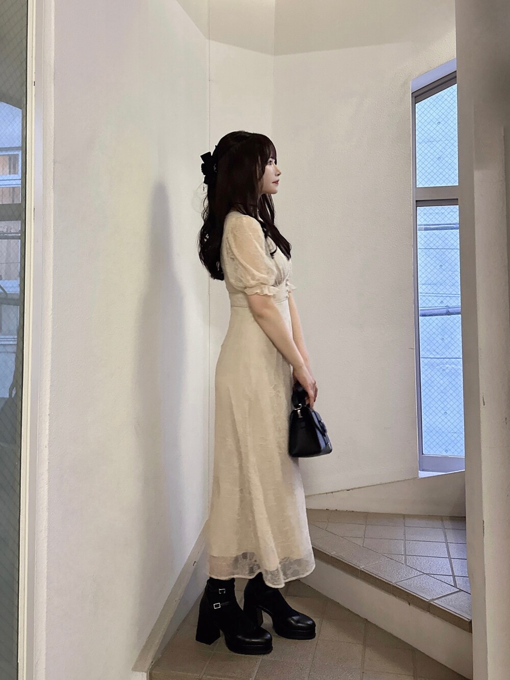 ベージュ系のワンピース、ブラック系のショルダーバッグ、ブラック系のパンプスを着用したレディースの夏コーディネートの2枚目の写真