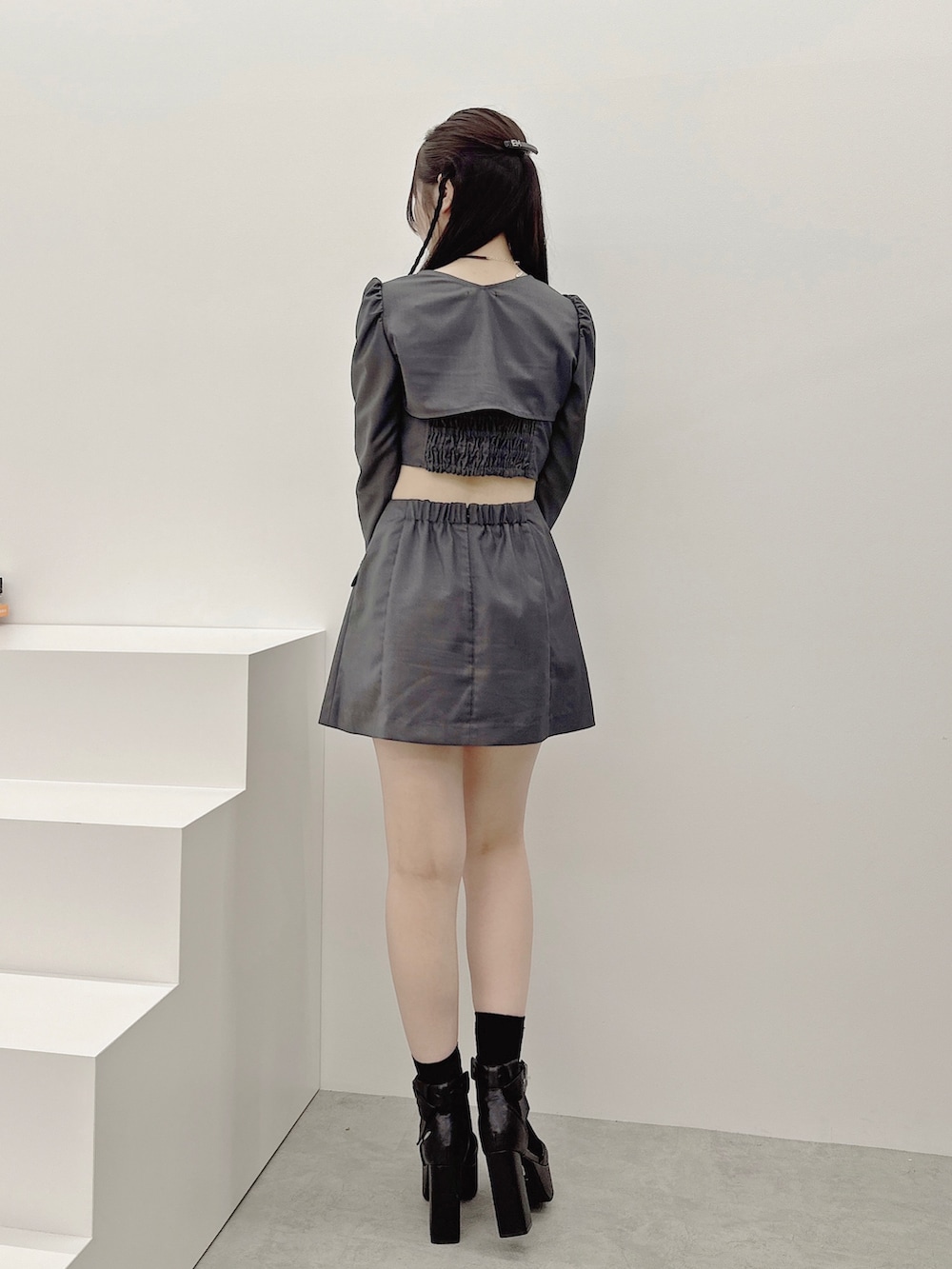 グレー系のワンピース、ブラック系のパンプス、ブラック系のバレッタ/ヘアクリップを着用したレディースの秋コーディネートの4枚目の写真