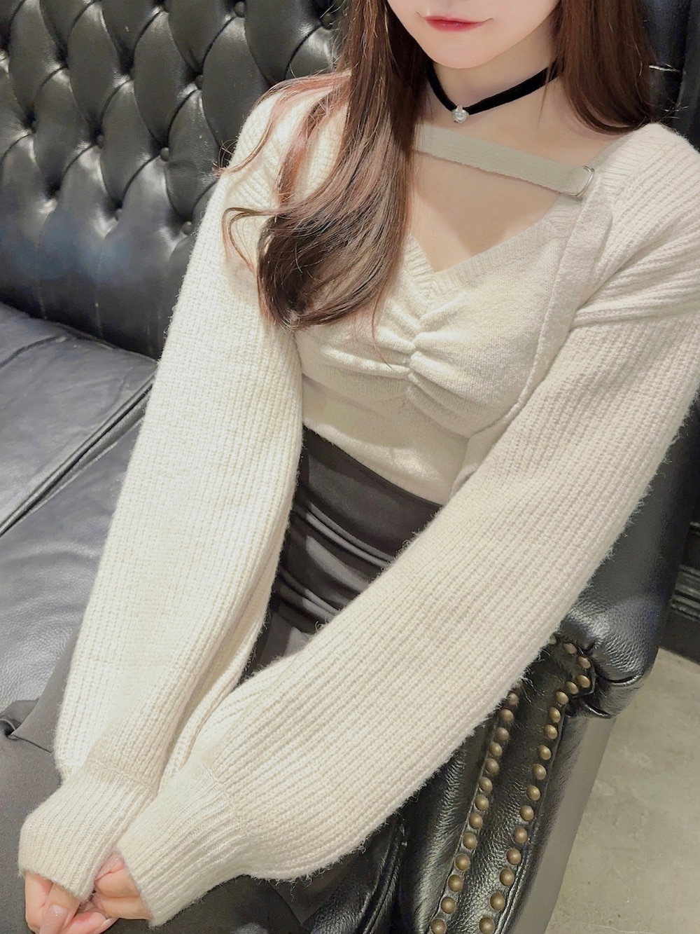 グレー系のニット/セーター、ブラック系のスカート、ブラック系のパンプスを着用したレディースの秋コーディネートの3枚目の写真