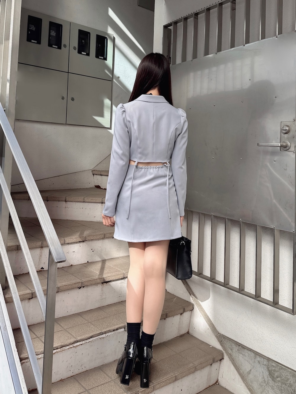 ブルー系のワンピース、ブラック系のショルダーバッグ、その他のパンプスを着用したレディースの冬コーディネートの4枚目の写真