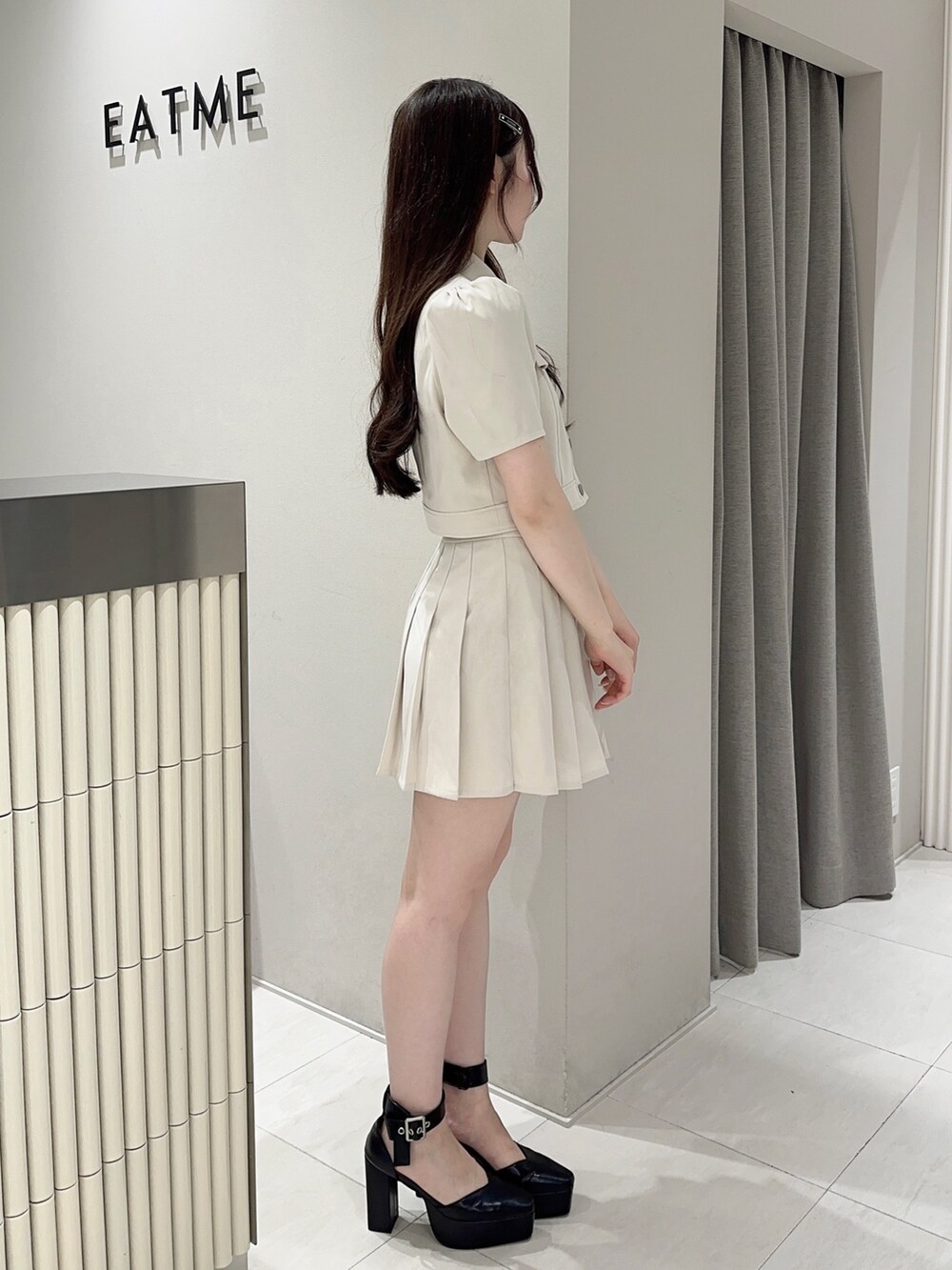 ホワイト系のスカート、ホワイト系のシャツ/ブラウス、ブラック系のパンプスを着用したレディースの夏コーディネートの2枚目の写真