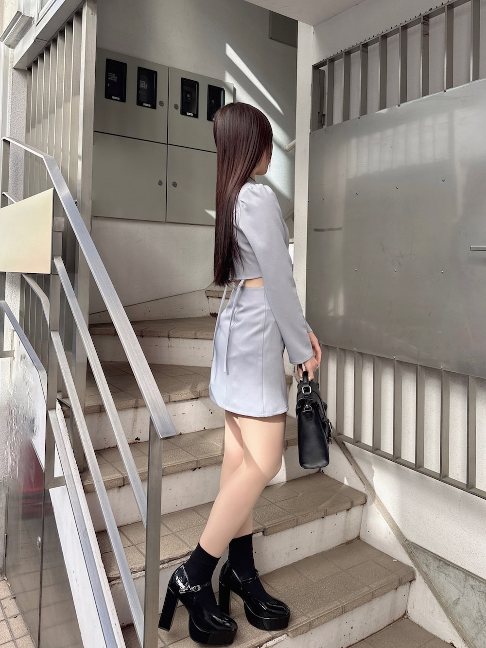 ブルー系のワンピース、ブラック系のショルダーバッグ、その他のパンプスを着用したレディースの冬コーディネートの3枚目の写真