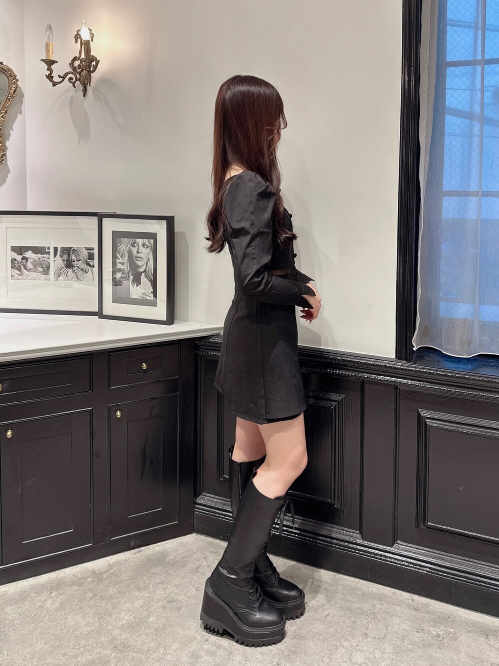 ブラック系のワンピース、ブラック系のブーツ、ブラック系のその他アウターを着用したレディースの秋コーディネートの2枚目の写真