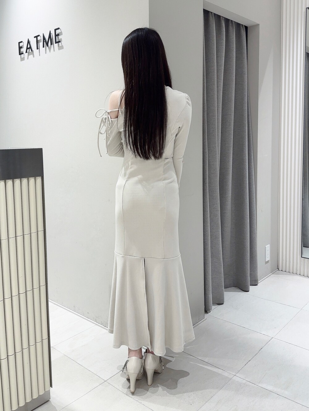 ホワイト系のワンピース、ホワイト系のブーツ、シルバー系のネックレスを着用したレディースの春コーディネートの4枚目の写真