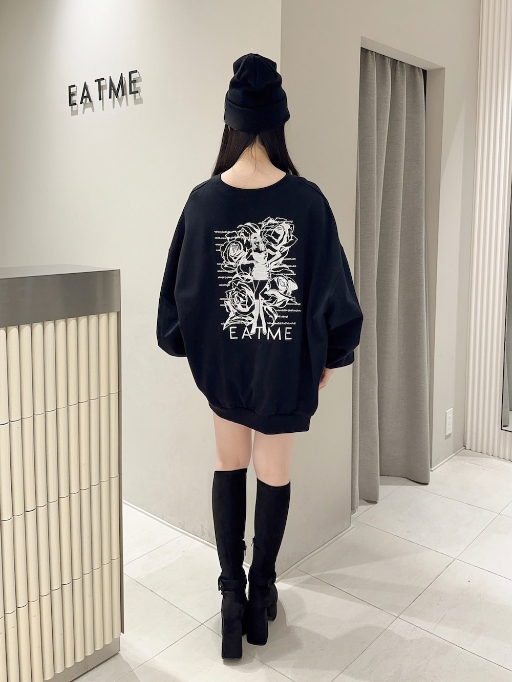 ブラック系のスウェット、ブラック系のデニムスカート、ブラック系のブーツを着用したレディースの秋コーディネートの4枚目の写真