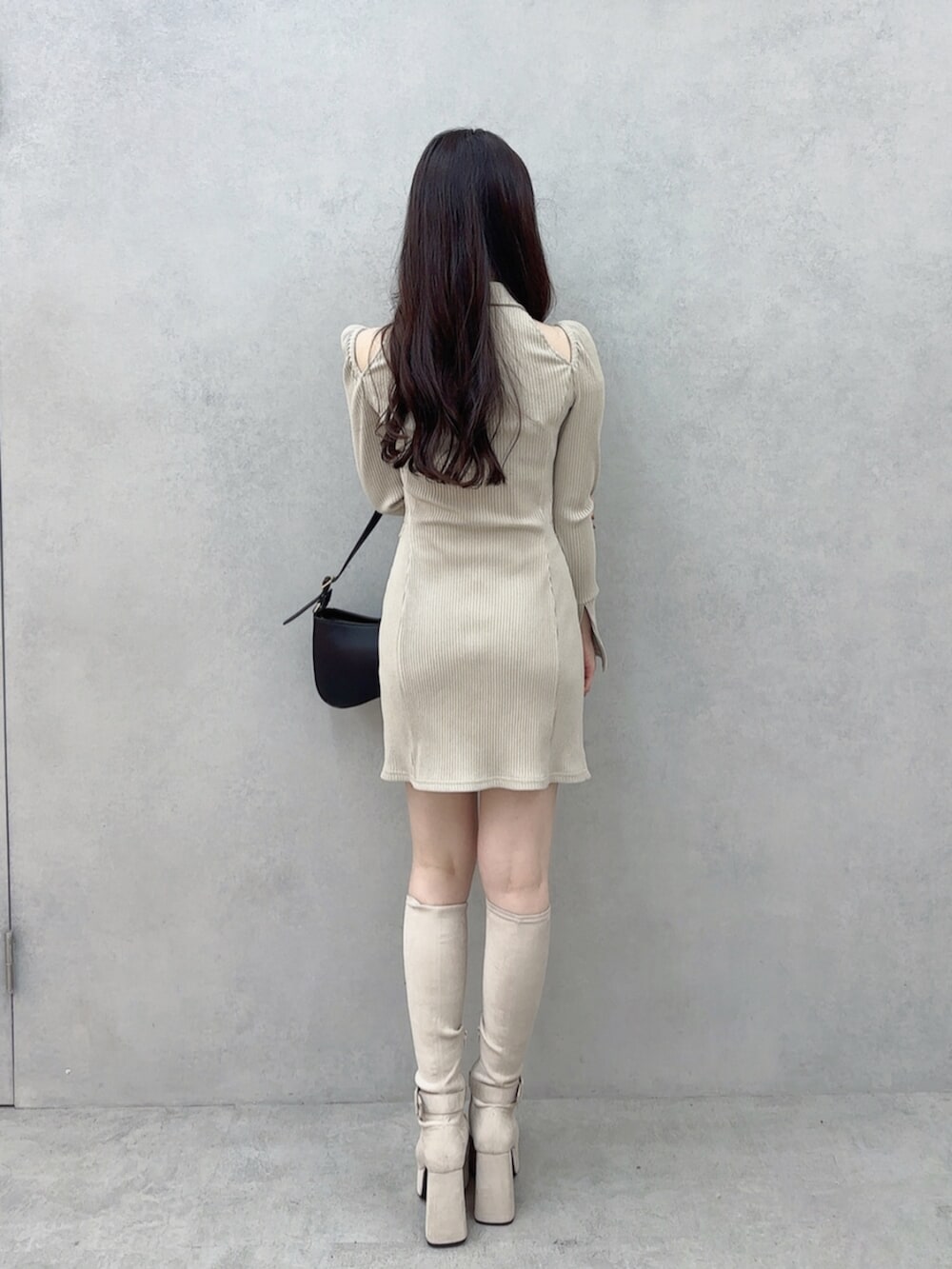 ブラック系のショルダーバッグ、ベージュ系のワンピース、ホワイト系のブーツを着用したレディースの秋コーディネートの4枚目の写真