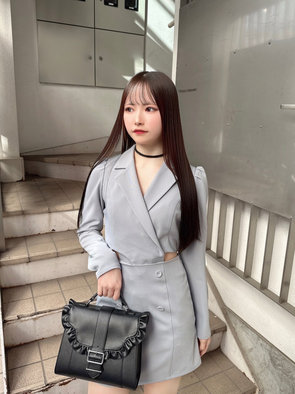 ブルー系のワンピース、ブラック系のショルダーバッグ、その他のパンプスを着用したレディースの冬コーディネートの5枚目の写真