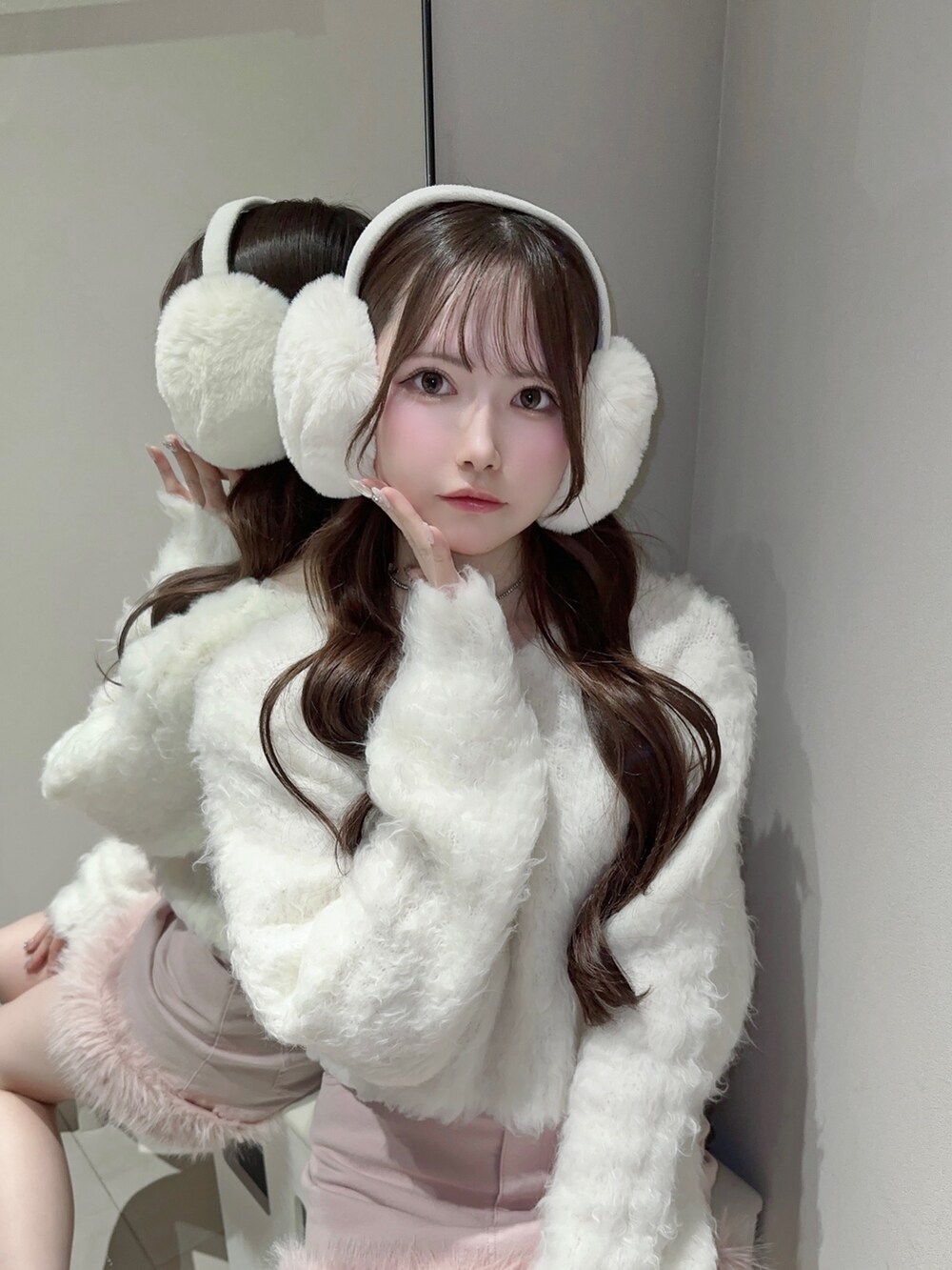 ピンク系のデニムスカート、ホワイト系のニット/セーター、ホワイト系のブーツを着用したレディースの冬コーディネートの5枚目の写真