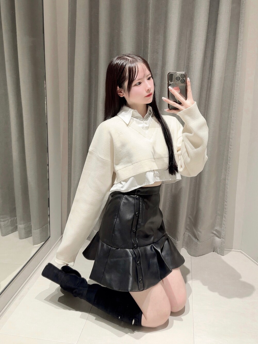 ブラック系のスカート、ホワイト系のシャツ/ブラウス、ブラック系のブーツを着用したレディースの秋コーディネートの4枚目の写真