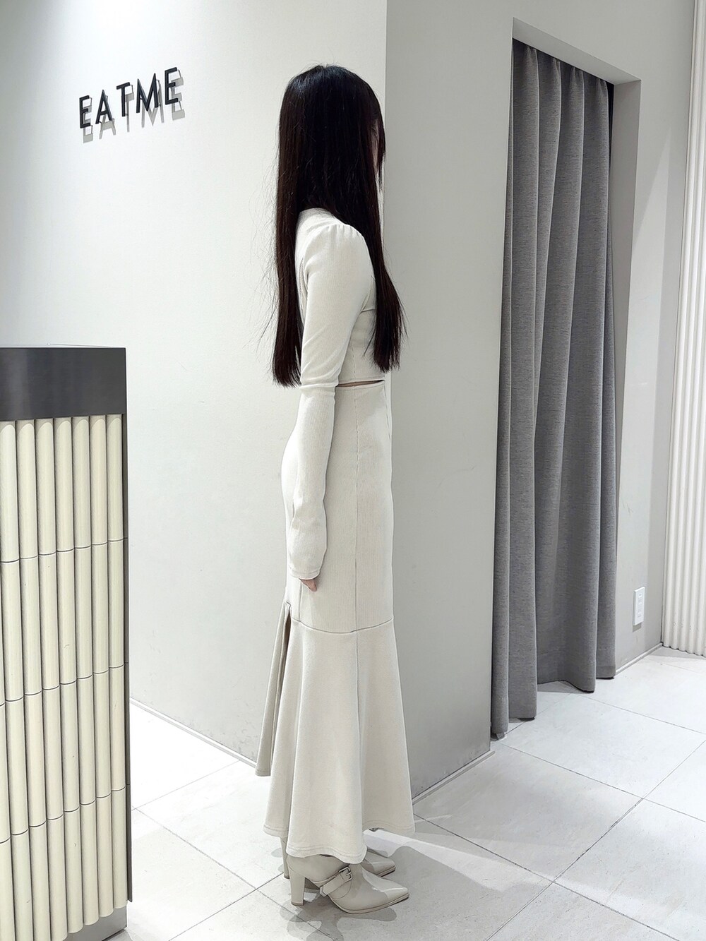 ホワイト系のワンピース、ホワイト系のブーツ、シルバー系のネックレスを着用したレディースの春コーディネートの3枚目の写真