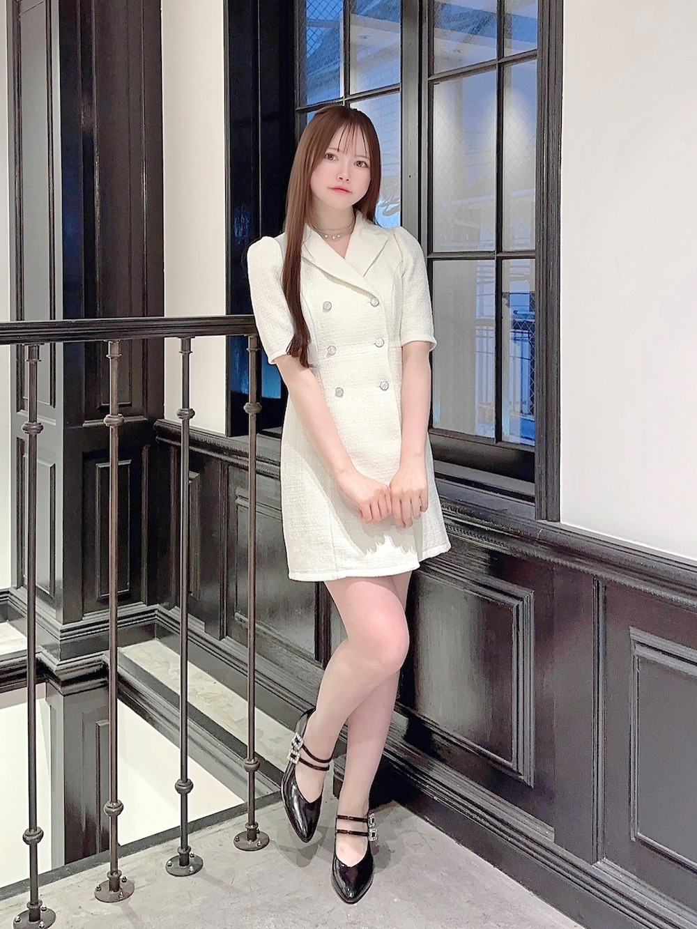 ホワイト系のワンピース、ブラック系のハンドバッグ、ブラック系のパンプスを着用したレディースの夏コーディネートの2枚目の写真