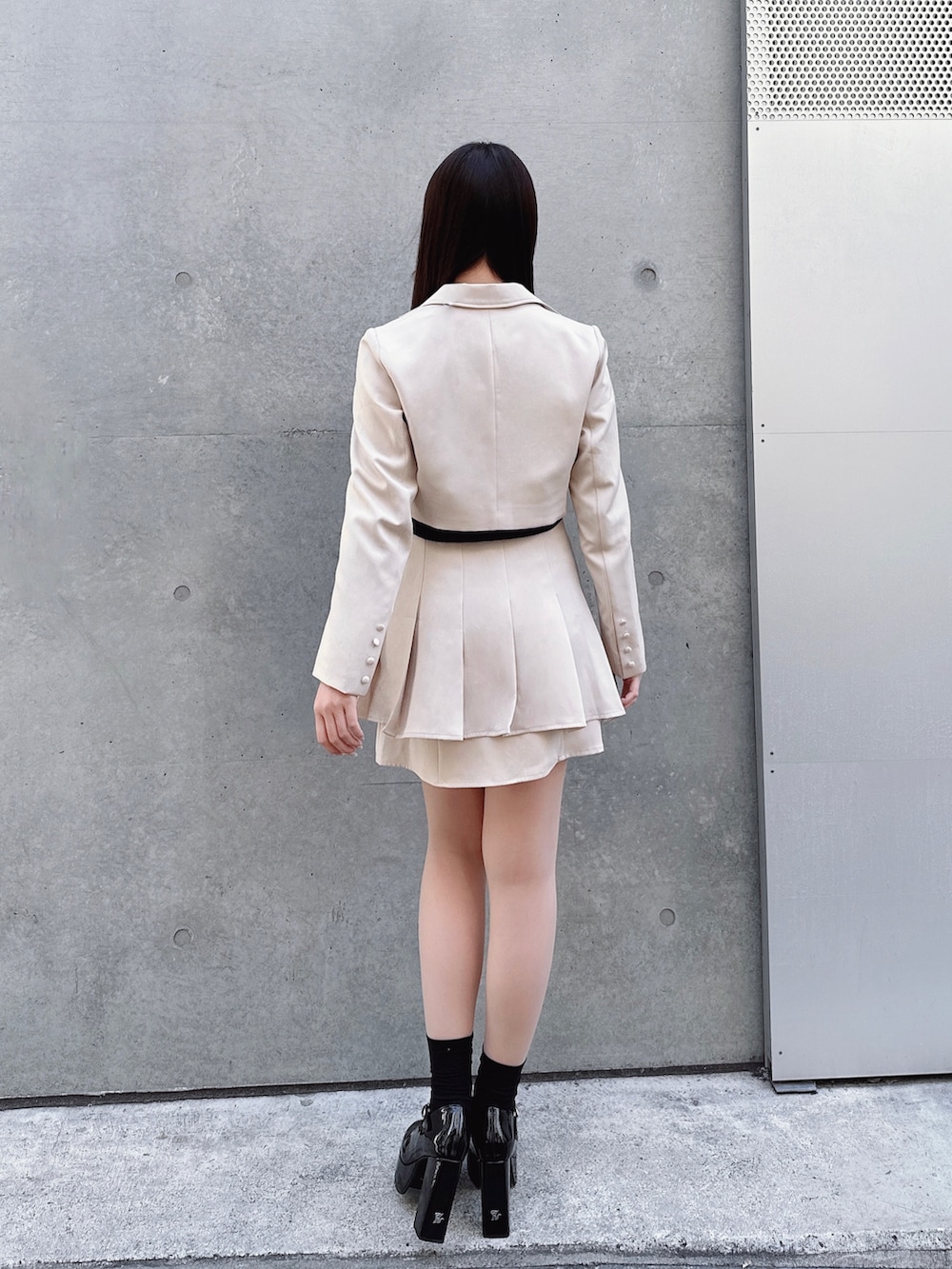 イエロー系のスカート、ブラック系のニット/セーター、イエロー系のテーラードジャケットを着用したレディースの春コーディネートの3枚目の写真