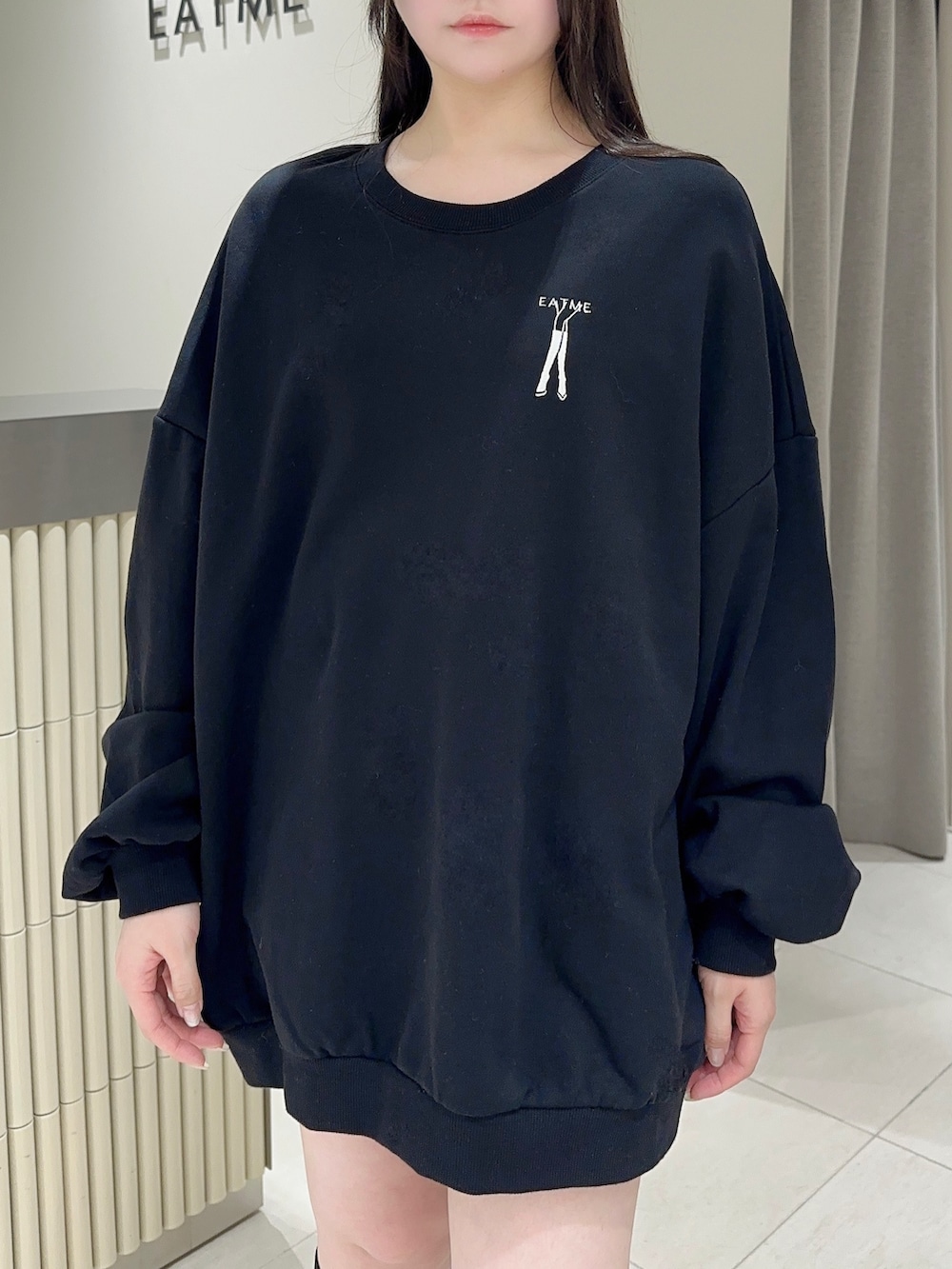 ブラック系のスウェット、ブラック系のデニムスカート、ブラック系のブーツを着用したレディースの秋コーディネートの5枚目の写真