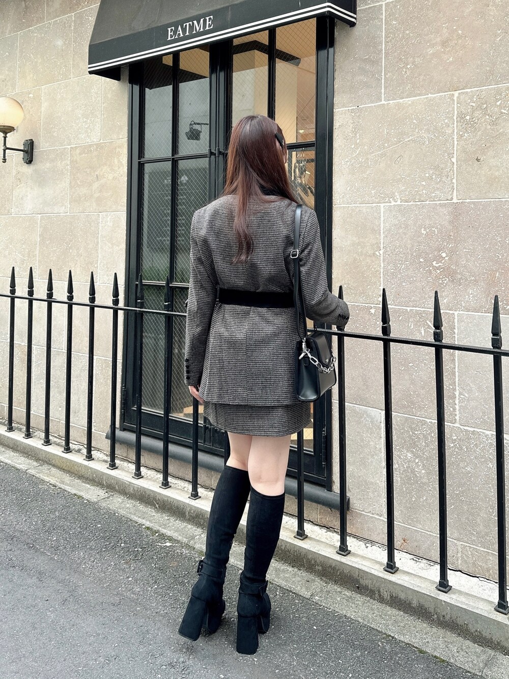 ブラック系のショルダーバッグ、ブラック系のTシャツ/カットソー、ブラウン系のスカートを着用したレディースの秋コーディネートの2枚目の写真