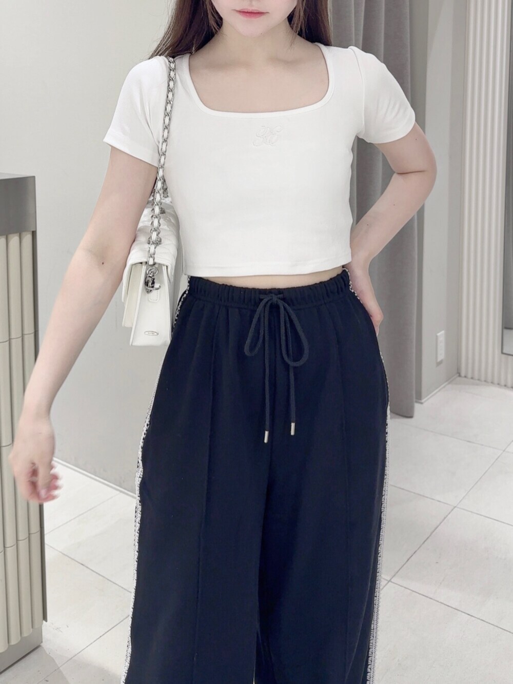 ホワイト系のスニーカー、ホワイト系のTシャツ/カットソー、ホワイト系のショルダーバッグを着用したレディースの夏コーディネートの5枚目の写真