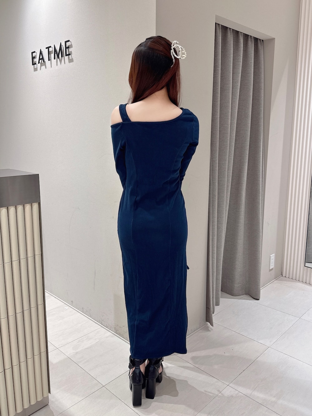 ブルー系のワンピース、ブラック系のパンプスを着用したレディースの秋コーディネートの3枚目の写真