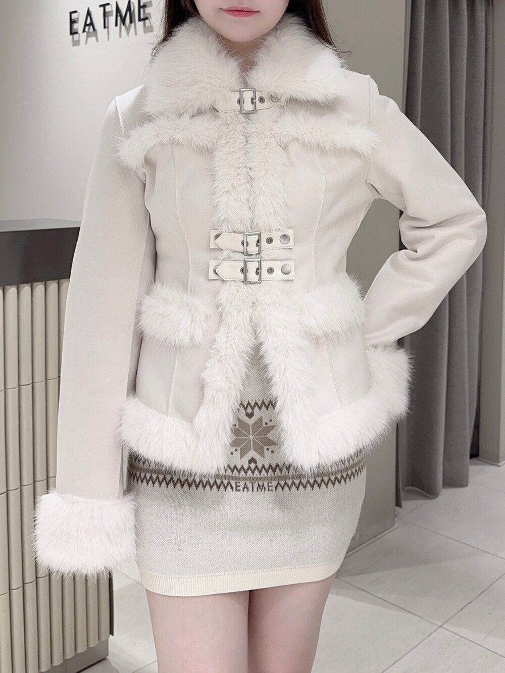 ブラウン系のショルダーバッグ、ホワイト系のブーツ、ホワイト系のスカートを着用したレディースの秋コーディネートの6枚目の写真