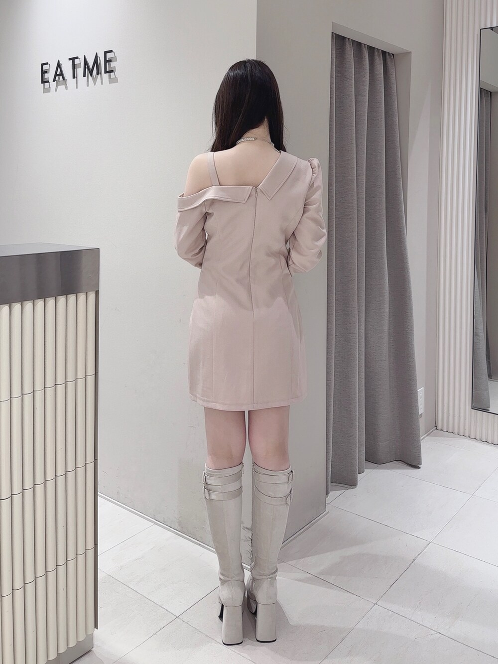 ピンク系のワンピース、ホワイト系のブーツ、シルバー系のネックレスを着用したレディースの冬コーディネートの4枚目の写真