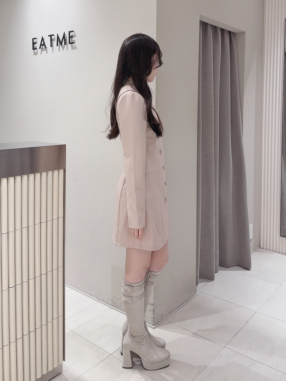 ピンク系のワンピース、ホワイト系のブーツ、シルバー系のネックレスを着用したレディースの冬コーディネートの3枚目の写真