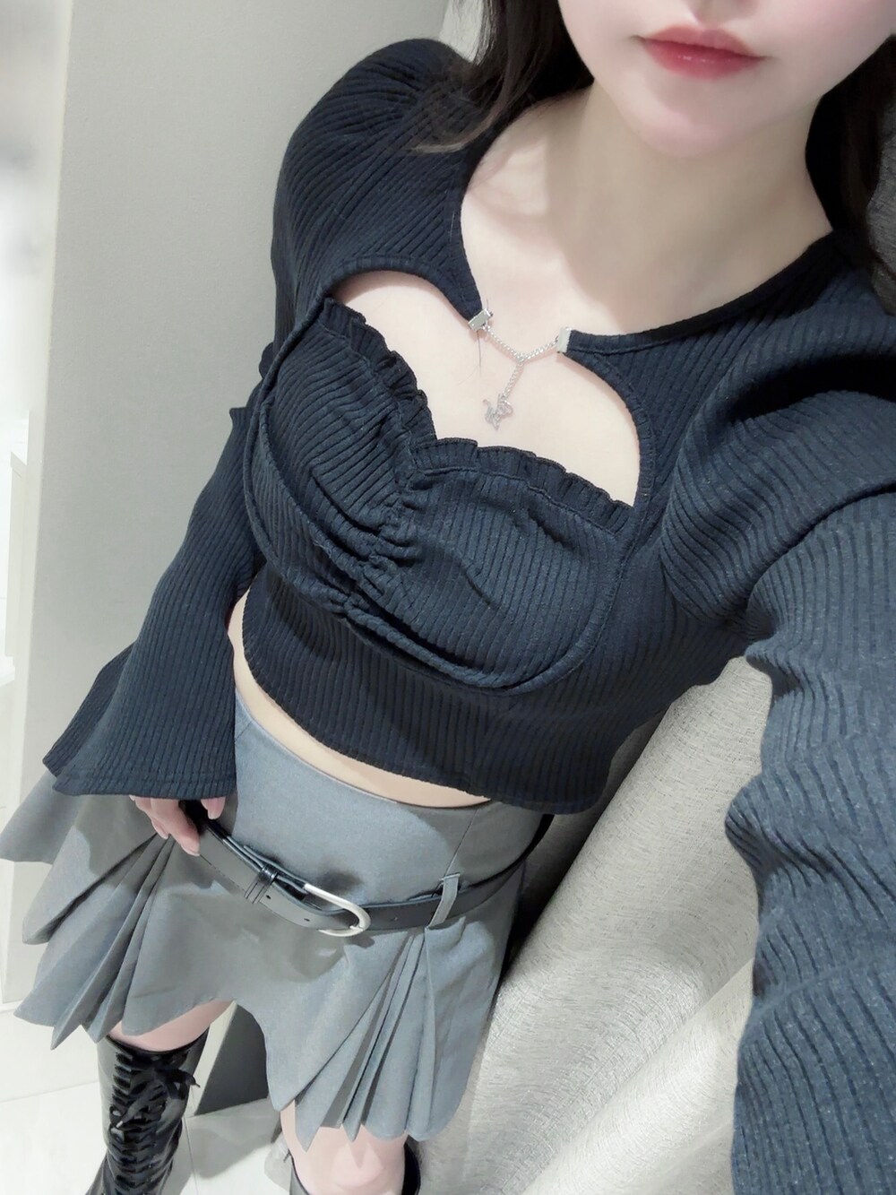 ブラック系のTシャツ/カットソー、グレー系のスカート、ブラック系のブーツを着用したレディースの冬コーディネートの7枚目の写真