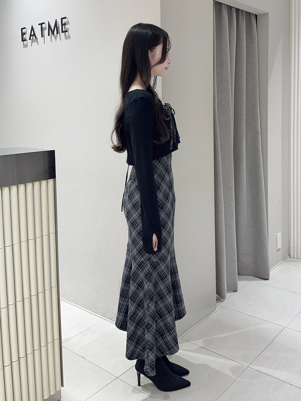 ブラック系のワンピース、ブラック系のブーツを着用したレディースの秋コーディネートの3枚目の写真