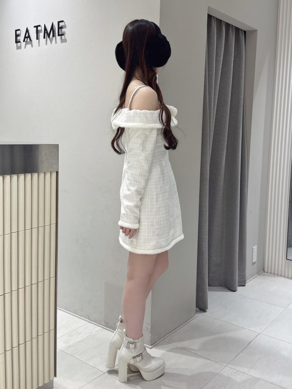 ホワイト系のブーツ、ホワイト系のワンピース、シルバー系のネックレスを着用したレディースの冬コーディネートの2枚目の写真