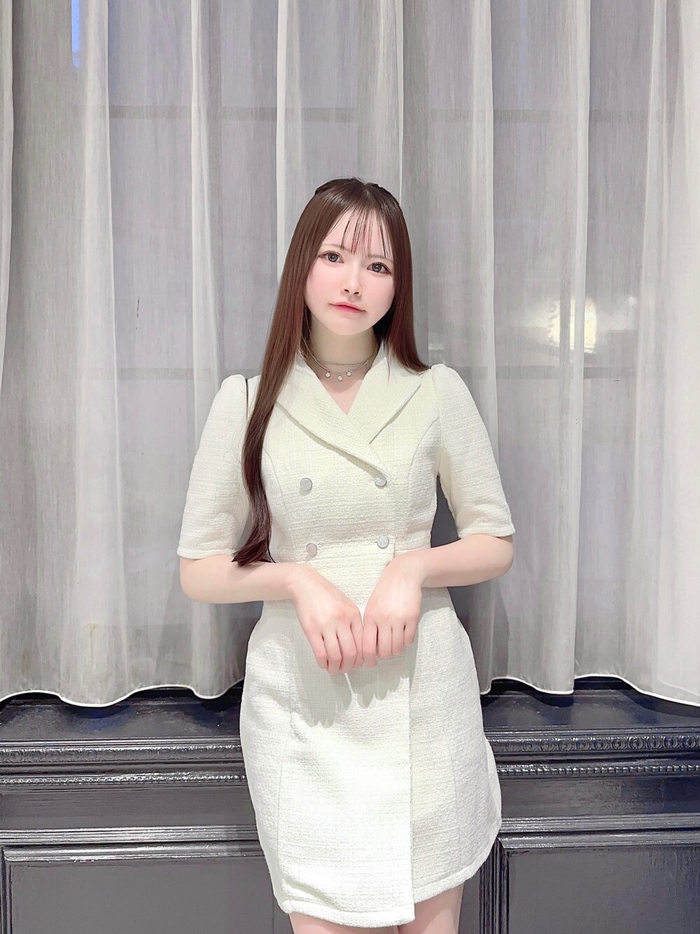 ホワイト系のワンピース、ブラック系のハンドバッグ、ブラック系のパンプスを着用したレディースの夏コーディネートの3枚目の写真