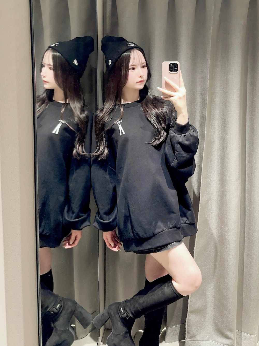 ブラック系のスウェット、ブラック系のデニムスカート、ブラック系のブーツを着用したレディースの秋コーディネートの6枚目の写真