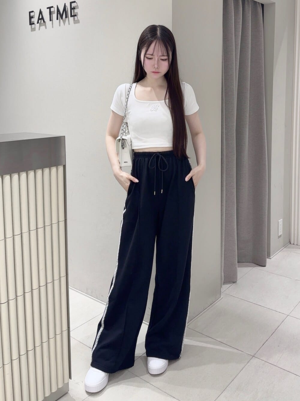 ホワイト系のスニーカー、ホワイト系のTシャツ/カットソー、ホワイト系のショルダーバッグを着用したレディースの夏コーディネートの2枚目の写真