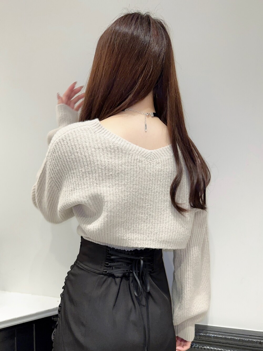 グレー系のニット/セーター、ブラック系のスカート、ブラック系のパンプスを着用したレディースの秋コーディネートの5枚目の写真